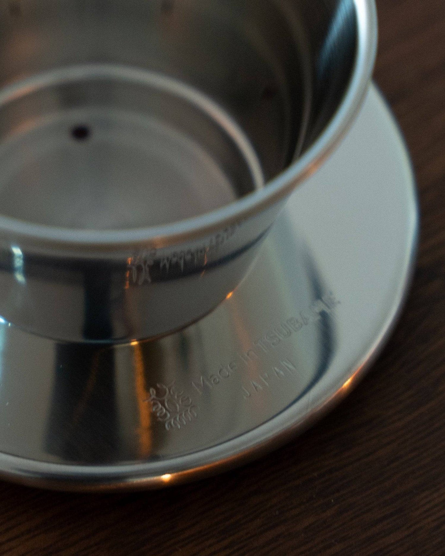 Kalita & TSUBAME WDS-155 stainless steel pour-over coffee dripper with three-hole design, crafted in Japan, shown on a wooden surface highlighting its elegant and durable construction for optimal coffee brewing