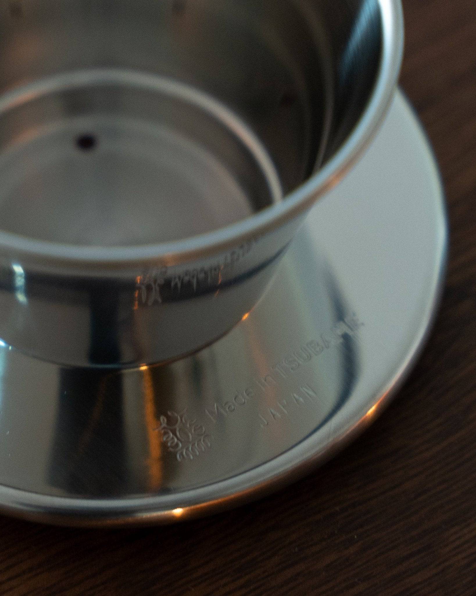 Kalita & TSUBAME WDS-155 stainless steel pour-over coffee dripper with three-hole design, crafted in Japan, shown on a wooden surface highlighting its elegant and durable construction for optimal coffee brewing