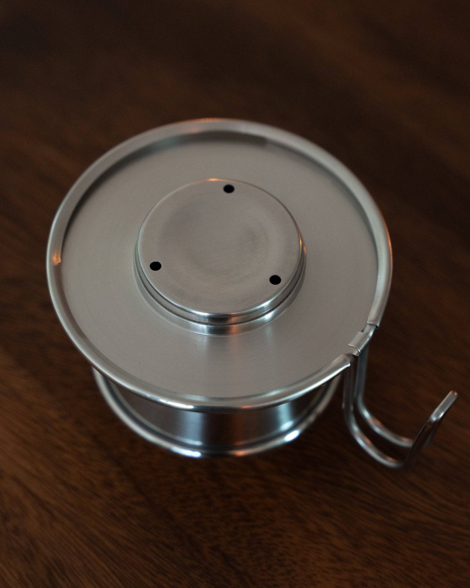 Kalita & TSUBAME WDS-155 stainless steel coffee dripper with three-hole design, handcrafted in Japan, on wooden surface. Elegant and durable pour-over coffee maker for optimal flavor extraction.