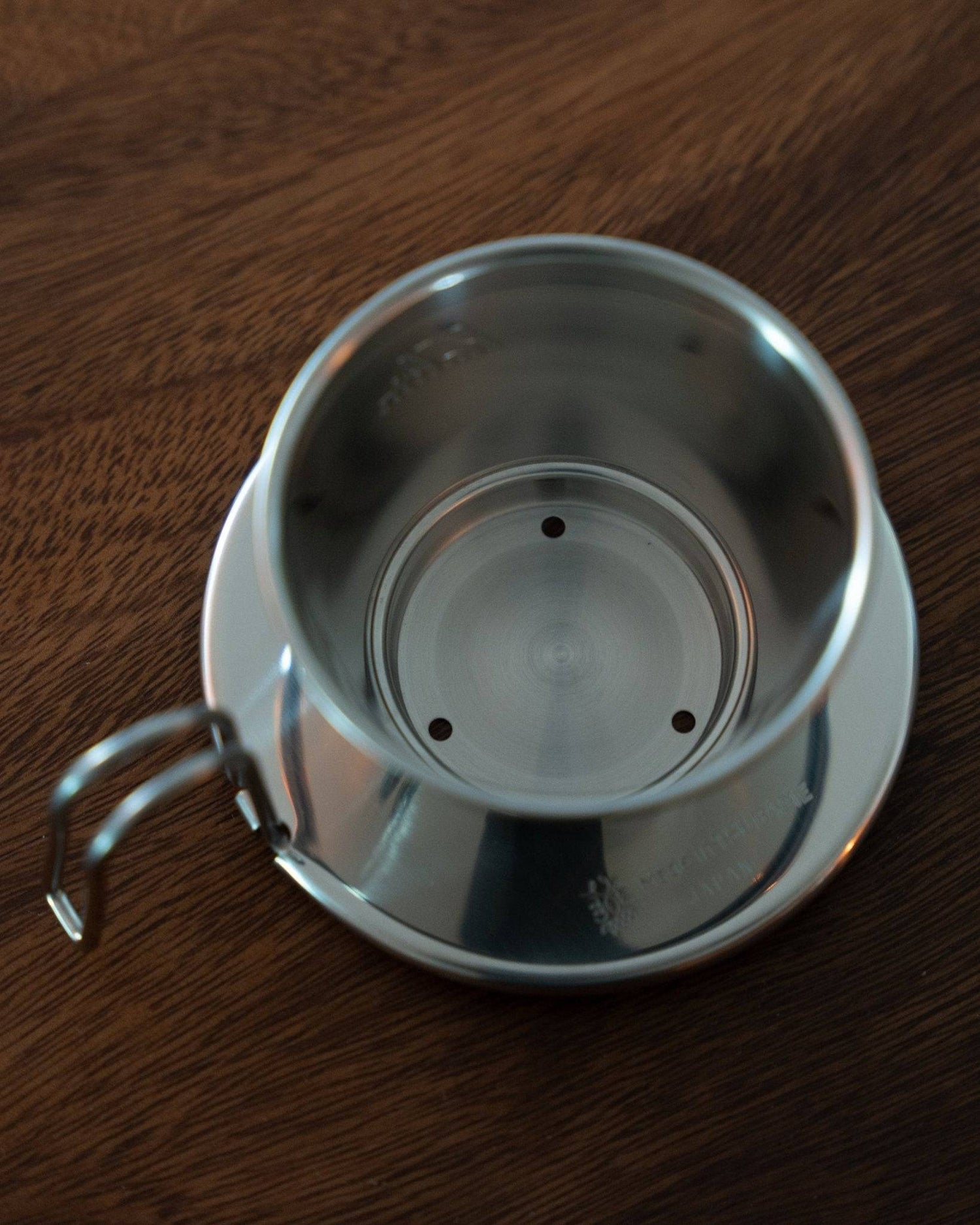 Kalita & TSUBAME WDS-155 stainless steel coffee dripper with three-hole design on wooden surface, showcasing its elegant shape and high-quality craftsmanship for optimal coffee brewing