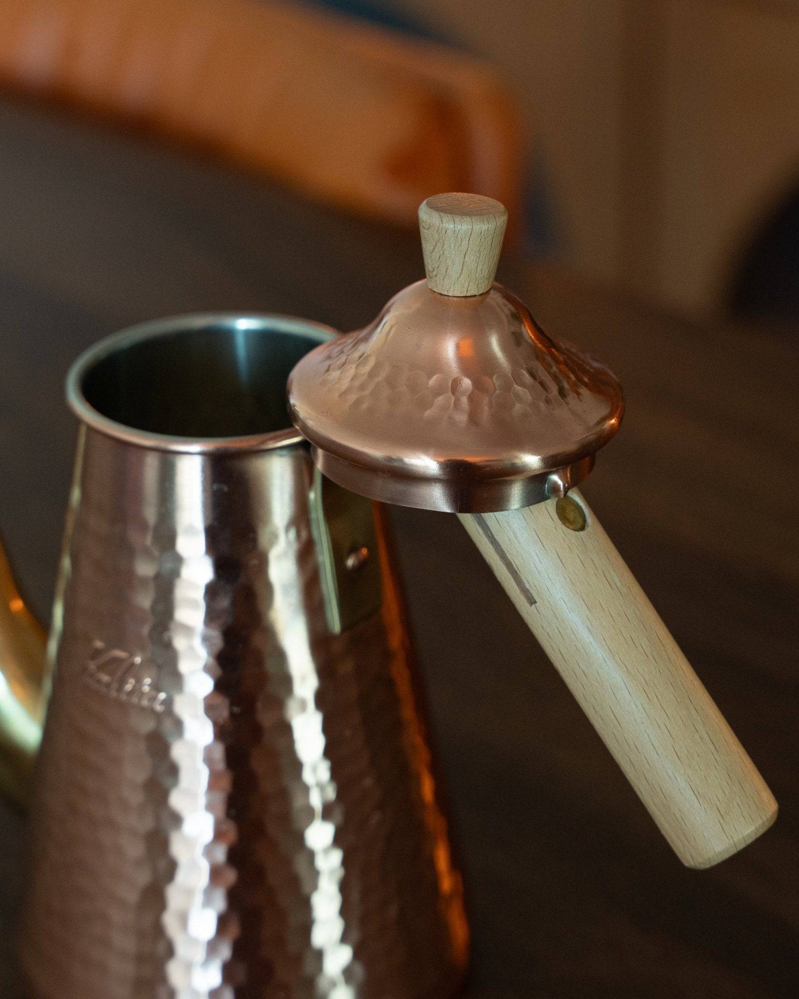 Kalita x Tsubame copper pour-over kettle with wooden handle and lid, showcasing its hammered texture and gooseneck spout for precise pouring, reflecting Japanese craftsmanship and design
