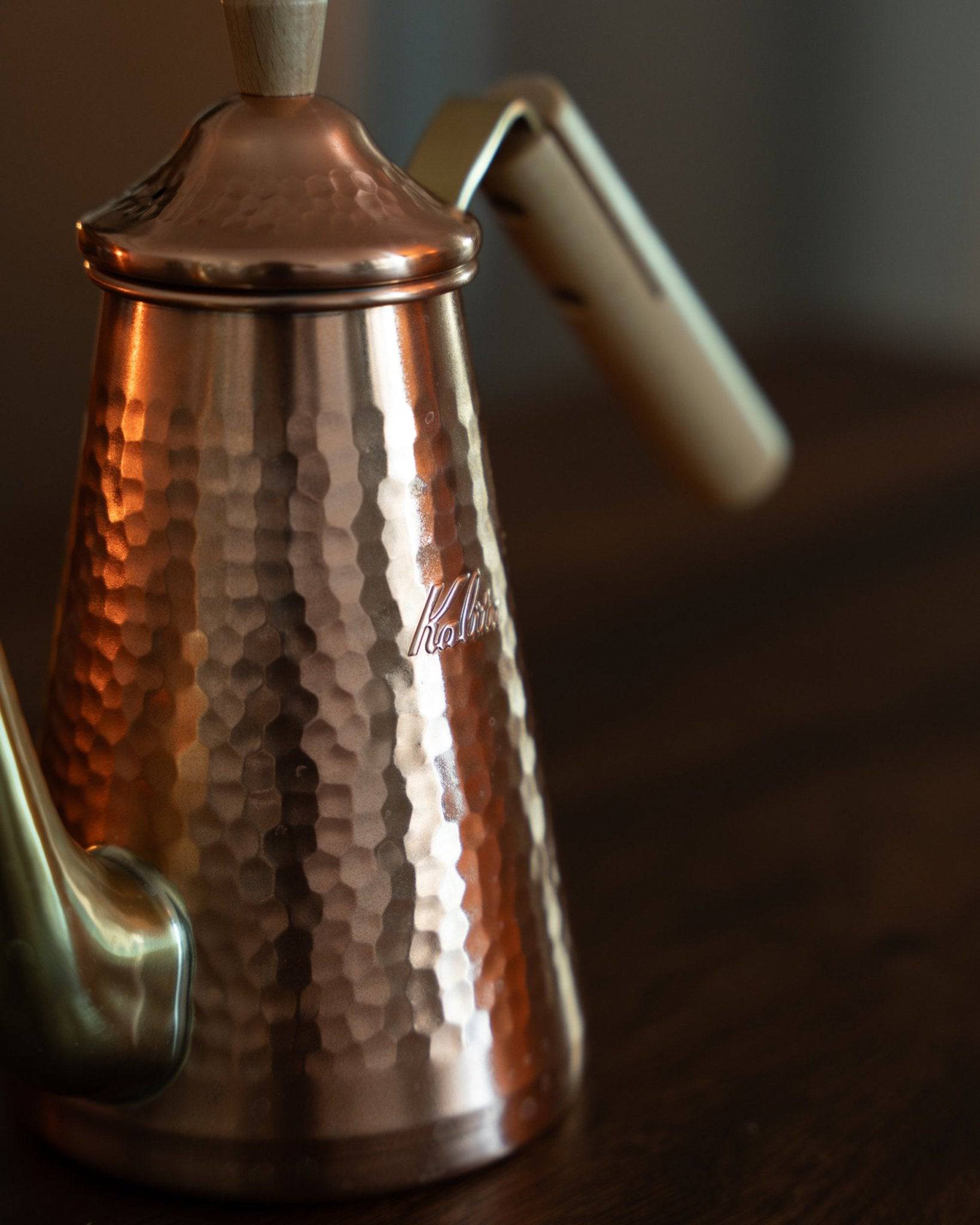 Kalita x Tsubame copper pour-over kettle with hammered texture, gooseneck spout, and wooden handle, showcasing Japanese craftsmanship and precision for brewing coffee