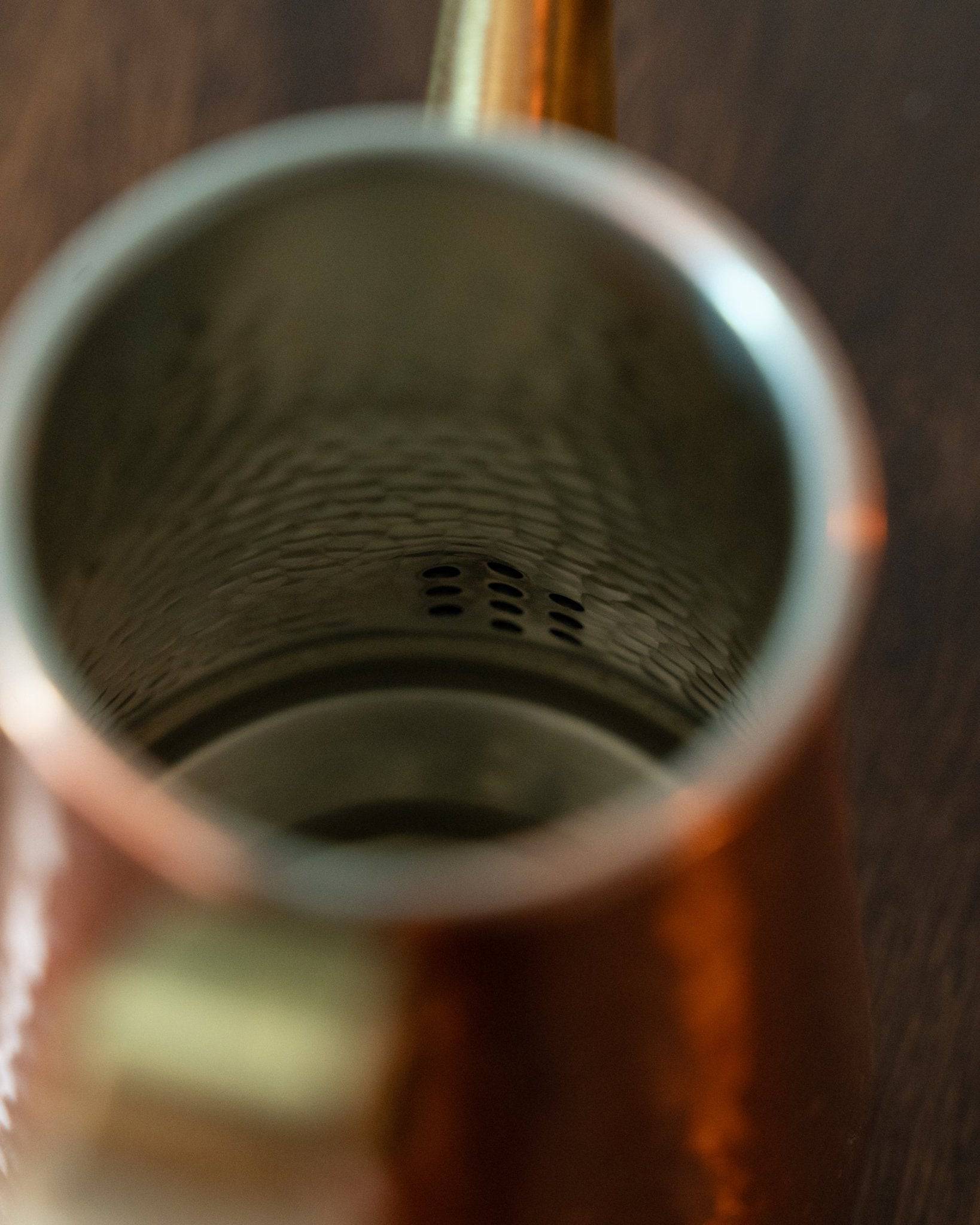 Close-up view of Kalita x Tsubame copper pour-over kettle interior, showcasing intricate honeycomb pattern and precision-crafted spout holes for optimal water flow control during coffee brewing