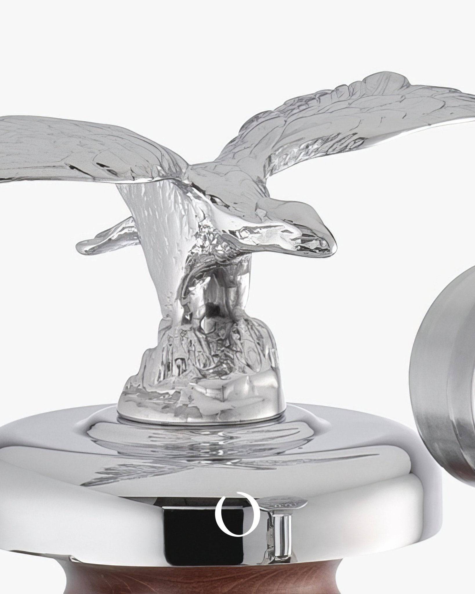 Silver eagle figurine atop La Pavoni Esperto Abile espresso machine, showcasing chrome body and wooden handle detail