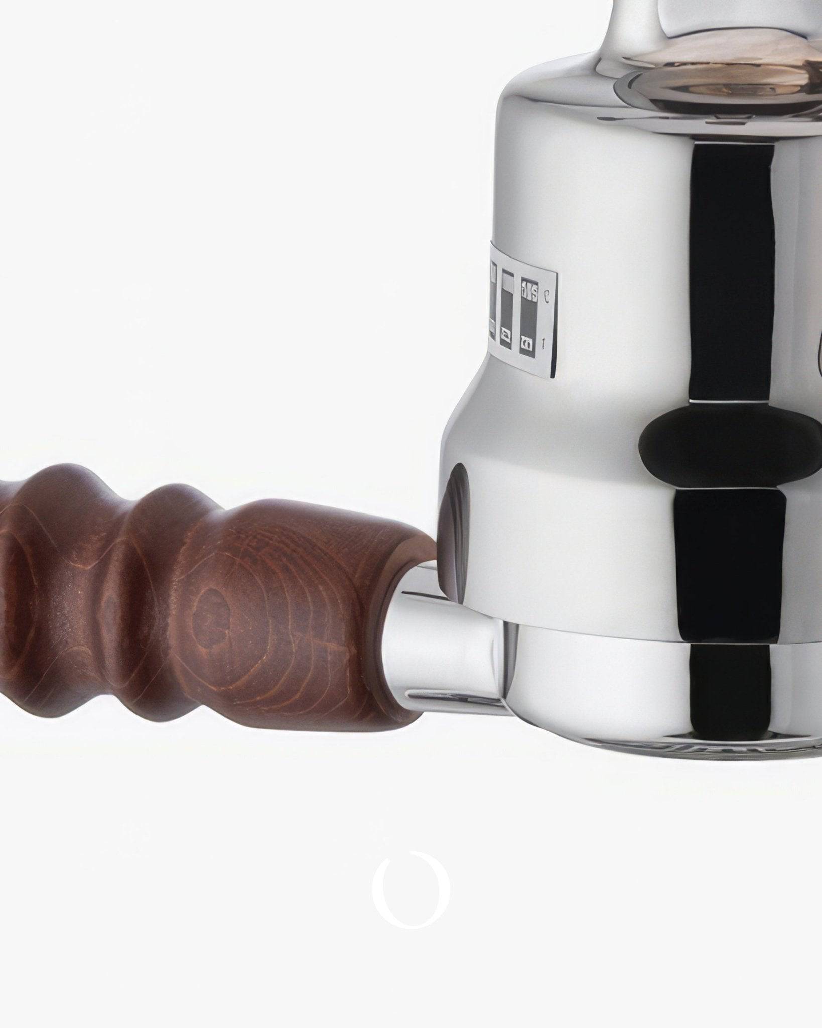 Close-up of a La Pavoni espresso machine featuring a shiny chrome body, wooden handle, and pressure gauge. The machine&