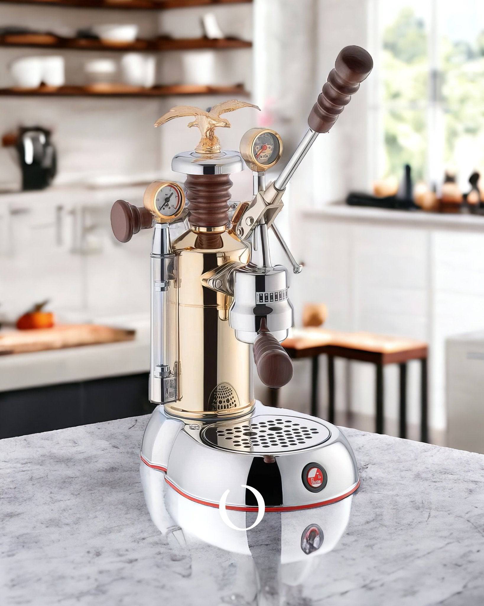 La Pavoni Esperto Competente lever espresso machine with gold-plated brass boiler, nickel-plated brass group head, rosewood handles, pressure gauges, and steam wands, displayed on marble countertop in modern kitchen setting.