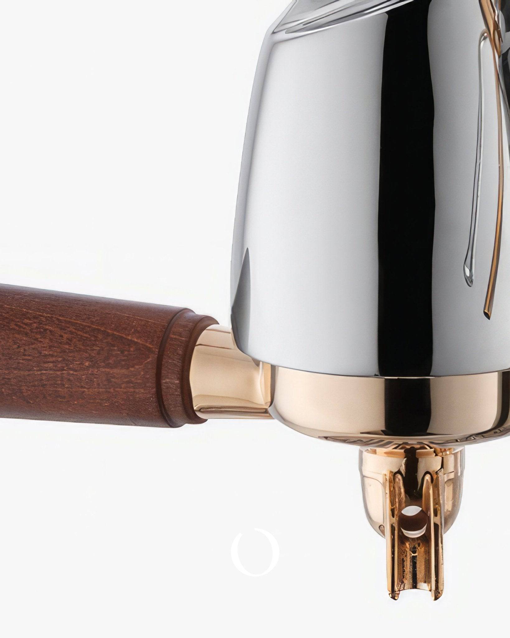 Close-up of La Pavoni EXPO Lever Espresso Machine featuring polished chrome body, gold-toned accents, and wooden handle. Showcases the elegant design and premium materials of this luxury coffee maker.