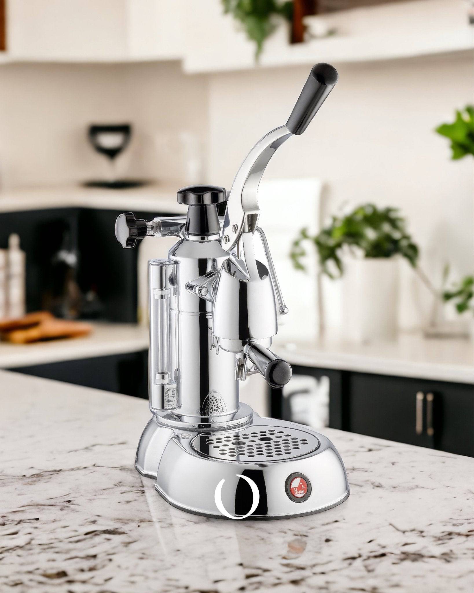 La Pavoni Stradivari Lusso lever espresso machine in chrome finish on marble kitchen countertop, featuring manual pressure control lever and steam wand for professional-grade coffee brewing at home