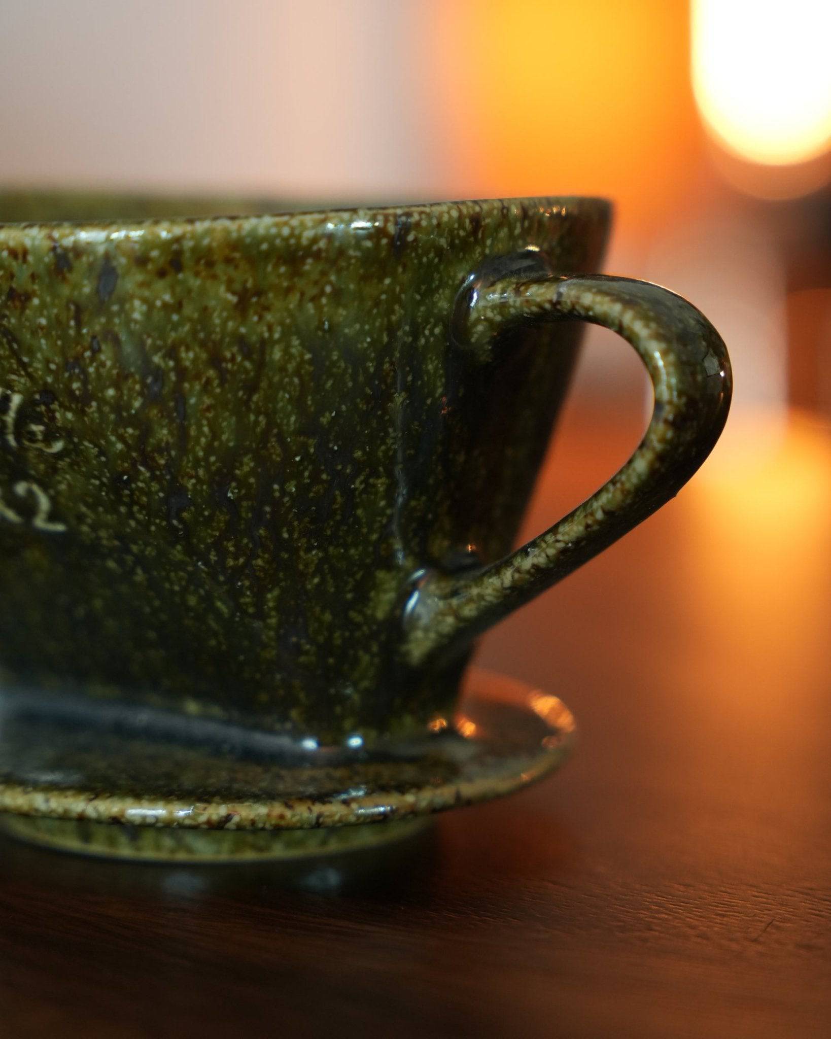 Melitta yellow-green ceramic pour-over coffee dripper with unique fan-shaped single-hole design, crafted from traditional Japanese Minoyaki pottery, illuminated by warm ambient lighting