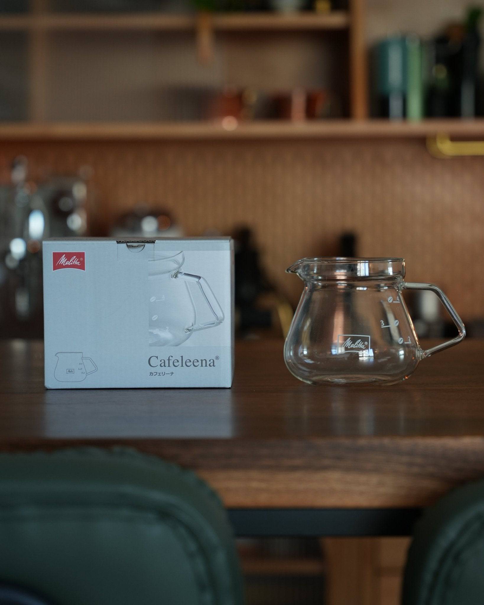 Melitta MJ500S glass coffee pot with product box on wooden kitchen counter, showcasing transparent design and ergonomic handle for comfortable pouring