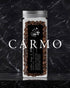 Glass jar filled with Carmo coffee beans from Ninety Plus, featuring a black label with white text and a butterfly logo, set against a dark marble background with white Carmo text overlay.