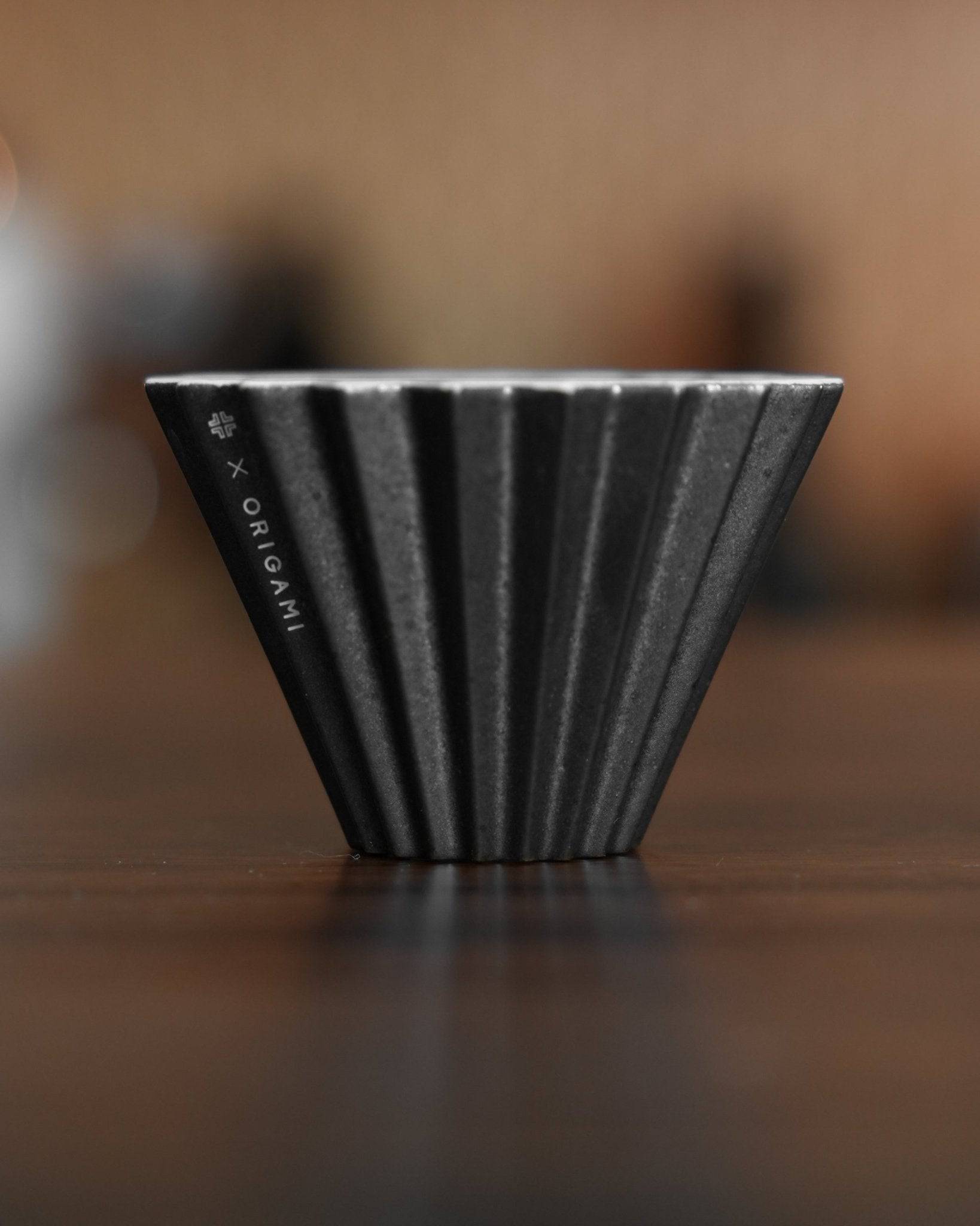 Ninety Plus Coffee Kone 10.1 mini brew dripper, black obsidian color, ribbed conical design, collaboration with Origami, for 10g specialty coffee beans, on wooden surface