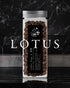 Glass jar filled with Ninety Plus Lotus coffee beans, featuring a black label with white text and butterfly logo, set against a dark marble background with &