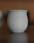 Ninety Plus Coffee Savour Cup in basalt white, showcasing a sleek, round design inspired by volcanic rock. Textured matte finish on ceramic, perfect for savoring premium coffee extracts without filtration.