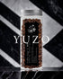 Glass jar filled with premium Ninety Plus Yuzo coffee beans, featuring a black label with white text and logo, set against a dramatic marble and striped background. The word "YUZO" is prominently displayed in white text below the jar.