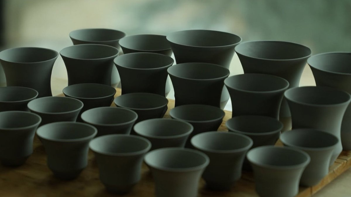香港工場木板上排列不同高度與杯口輪廓的 Coffee Stage Sharing Cup 未上釉杯坯