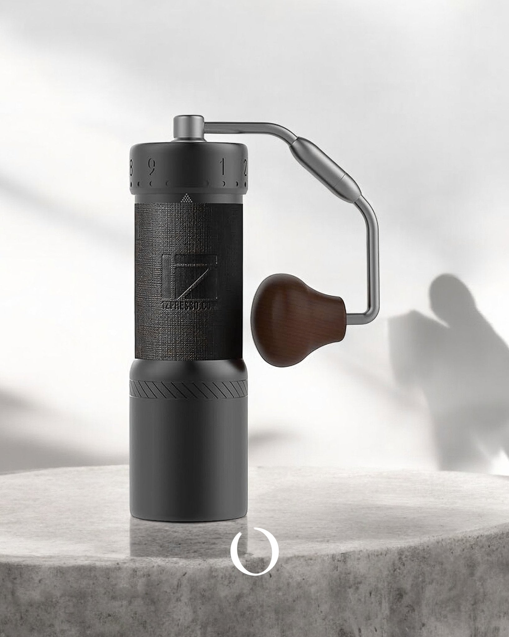 1Zpresso J Ultra manual coffee grinder with sleek black design, wooden handle, and precision adjustment mechanism, displayed on a concrete surface with soft shadows