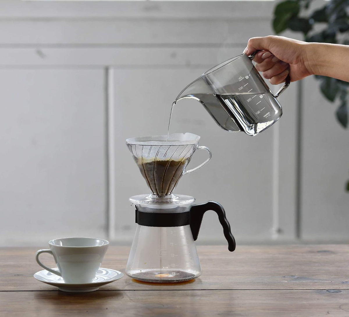Drip Kettle Air 搭配 V60 濾杯、分享壺與咖啡杯的桌面沖煮場景。