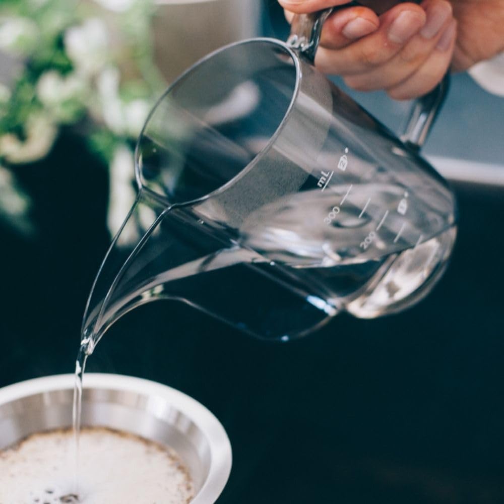 Drip Kettle Air 壺嘴與水流近景，正向金屬濾器注水。