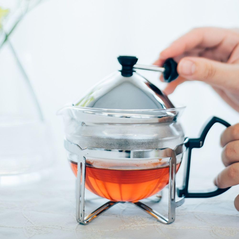 手持黑色把手的茶壺桌面展示