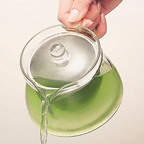 手持茶壺倒出綠茶的俯視畫面
