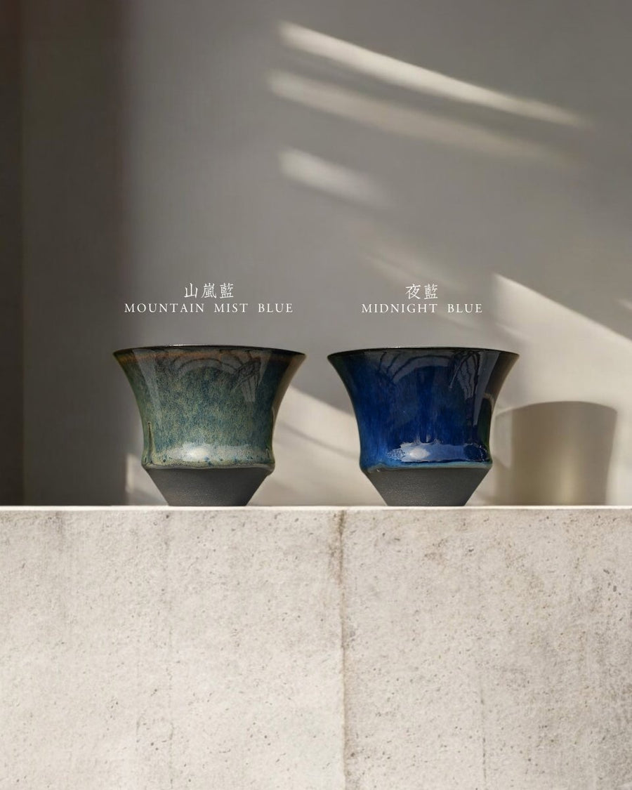 兩隻 Sharing Cup 系列小杯並排放在石台上，左邊青綠、右邊深藍