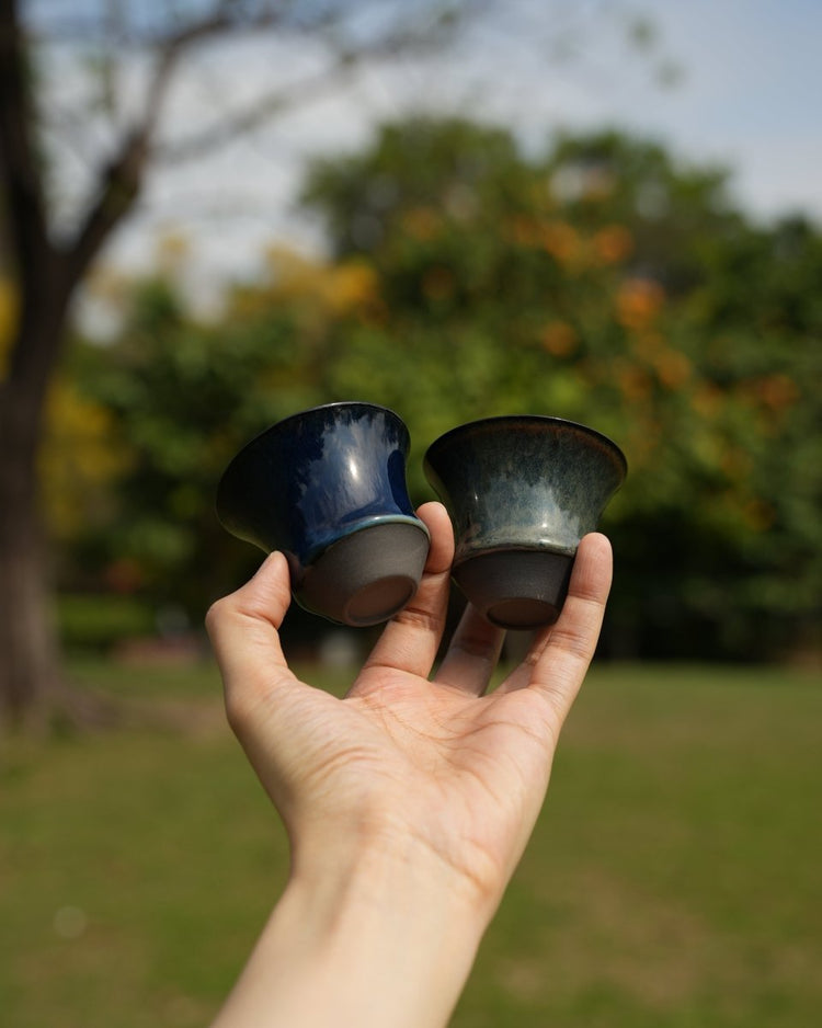 Two small Coffee Stage Sharing Cups held outdoors