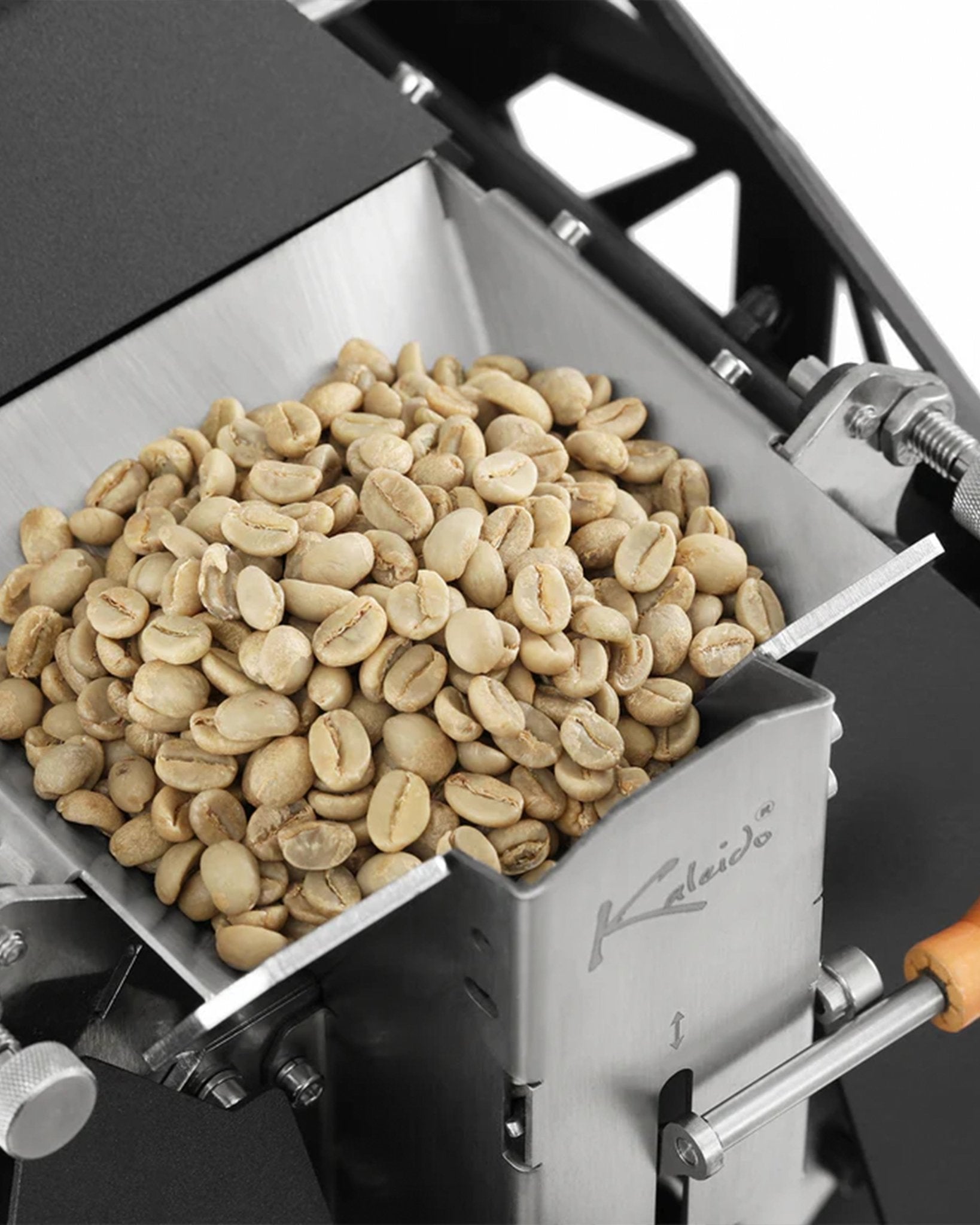 KALEIDO M2/M2S coffee roaster with collection tray filled with light-colored, unroasted coffee beans, showcasing the machine&