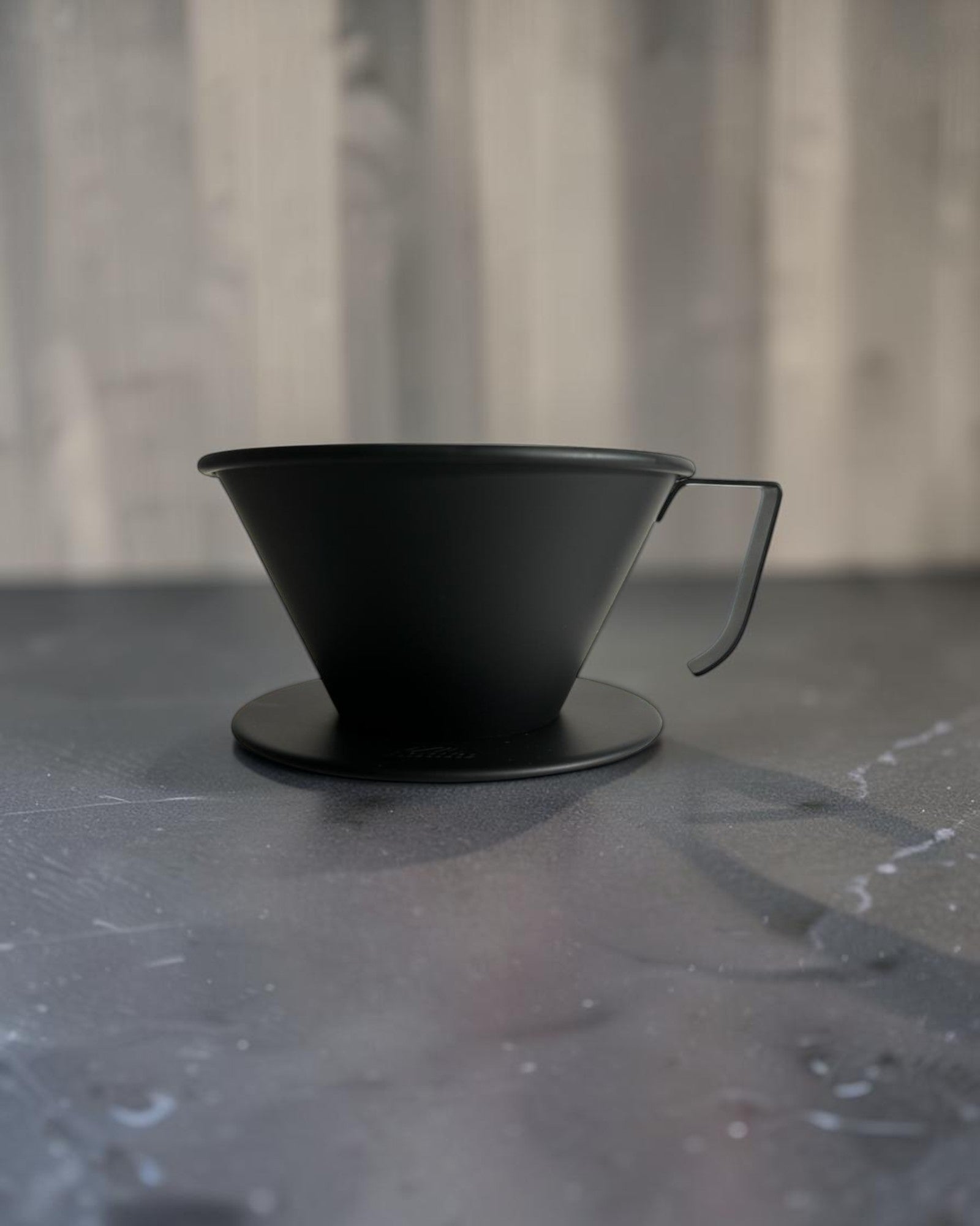 Kalita Black TSUBAME WDS-185 霧黑不鏽鋼濾杯放置於中灰石材咖啡吧檯的情境封面圖