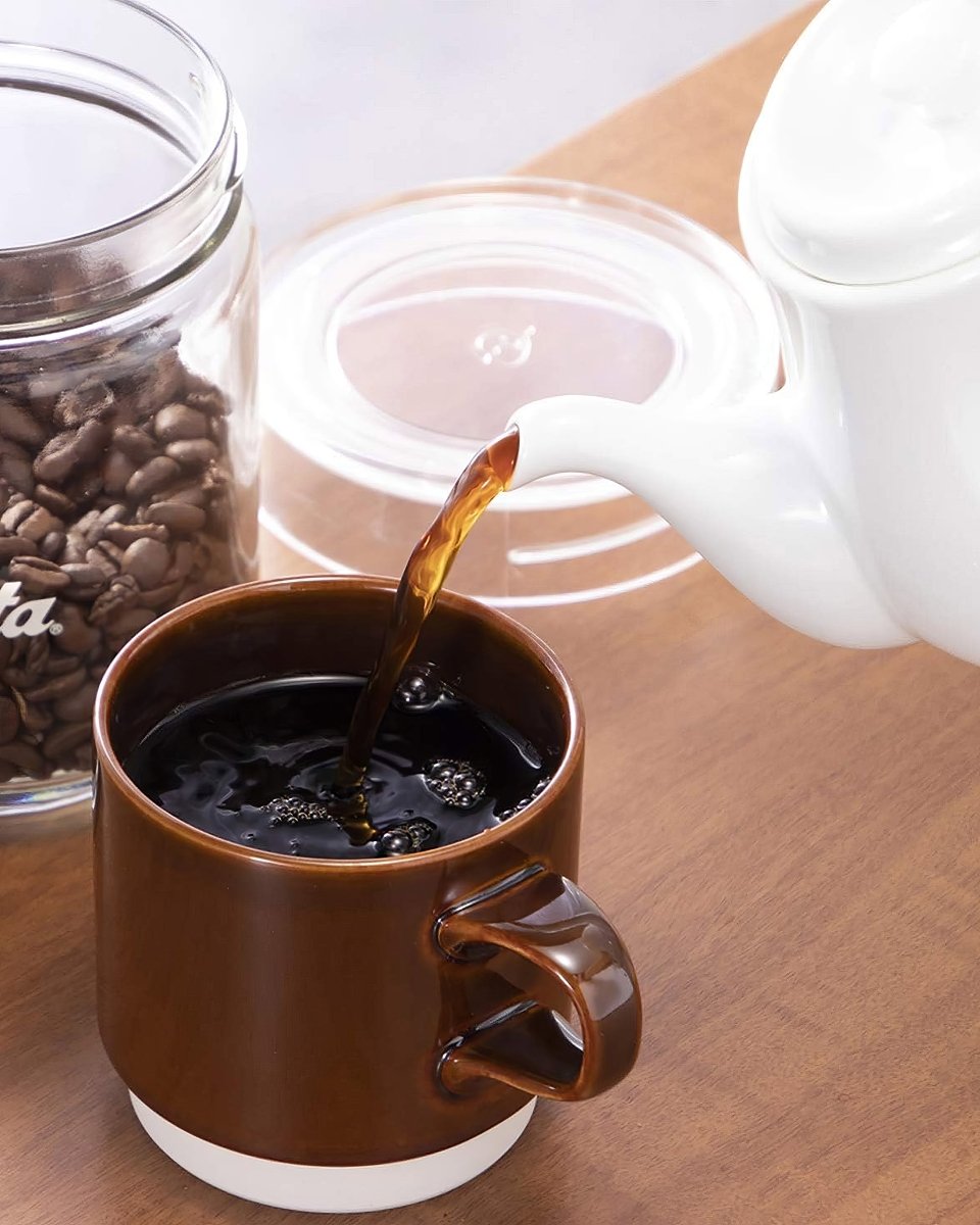 White Kalita HASAMI &amp; Kalita HA coffee server pouring coffee into a brown mug