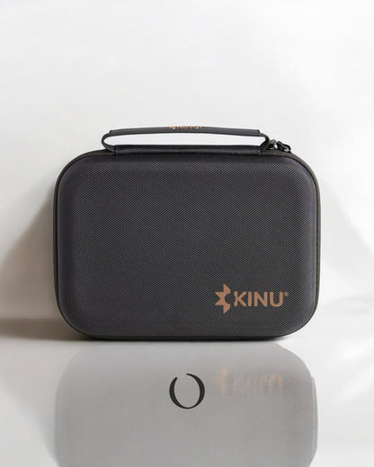 Black protective carrying case for Kinu M47 coffee grinder with hard shell, handle, and gold logo, designed for travel and storage