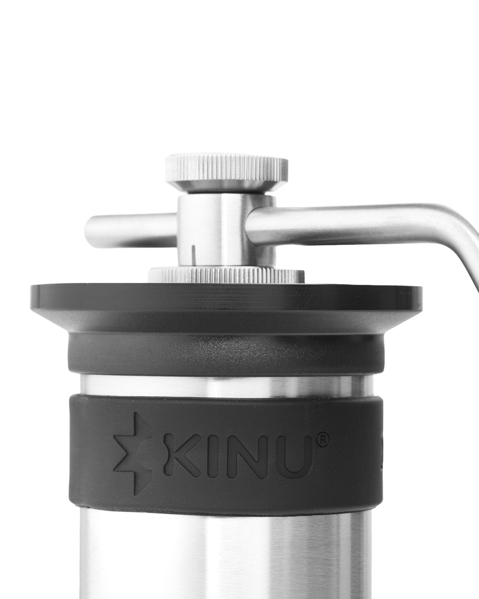 Close-up view of Kinu M47 Phoenix manual coffee grinder, showing stainless steel body, adjustment knob, and handle. The Kinu logo is visible on the black grip section.