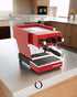 Red La Marzocco Linea Micra espresso machine on kitchen counter, compact design with dual boilers and WiFi connectivity, surrounded by modern kitchen appliances and decor