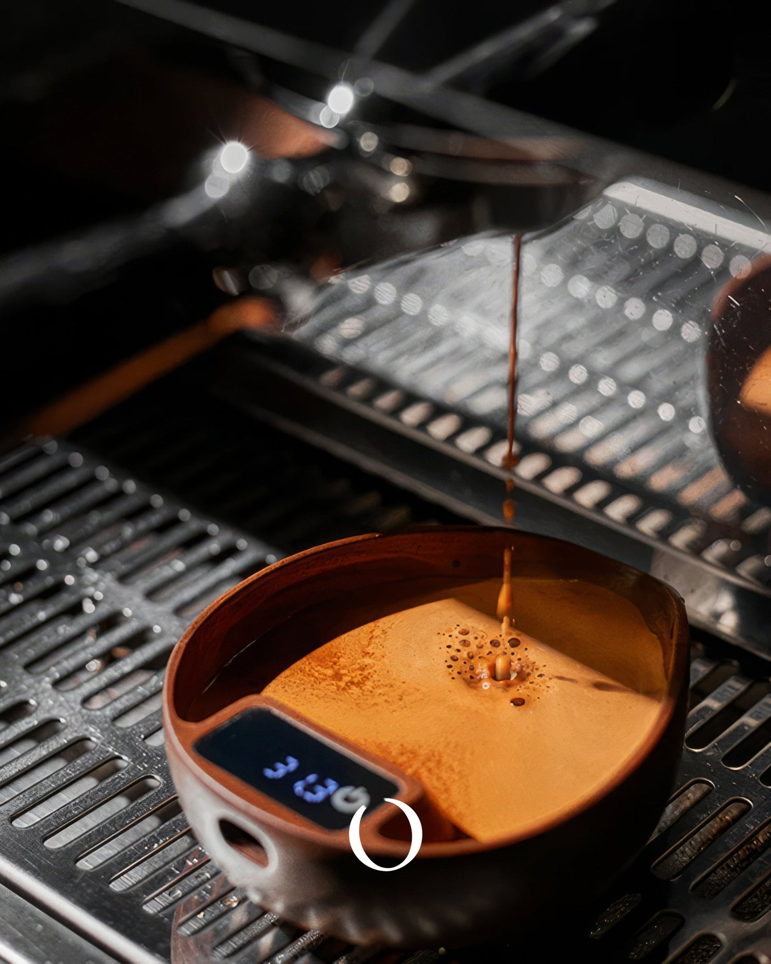 Coffee being poured into a wooden bowl on a digital scale displaying 3.84, placed on an espresso machine drip tray, showcasing precision measurement for brewing.