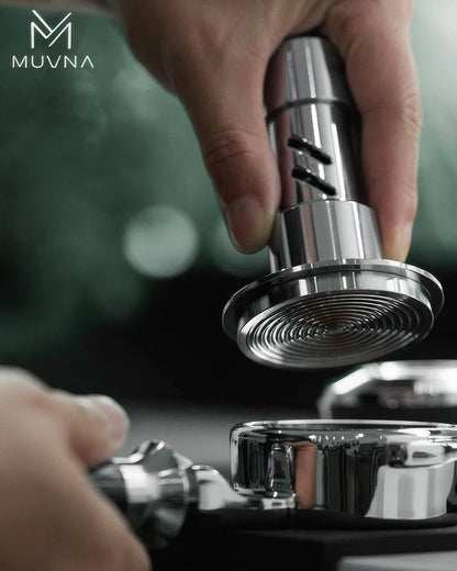 MUVNA coffee tamper with 30-pound constant pressure spring being used to compress ground coffee in a portafilter, showcasing precision and quality for espresso preparation