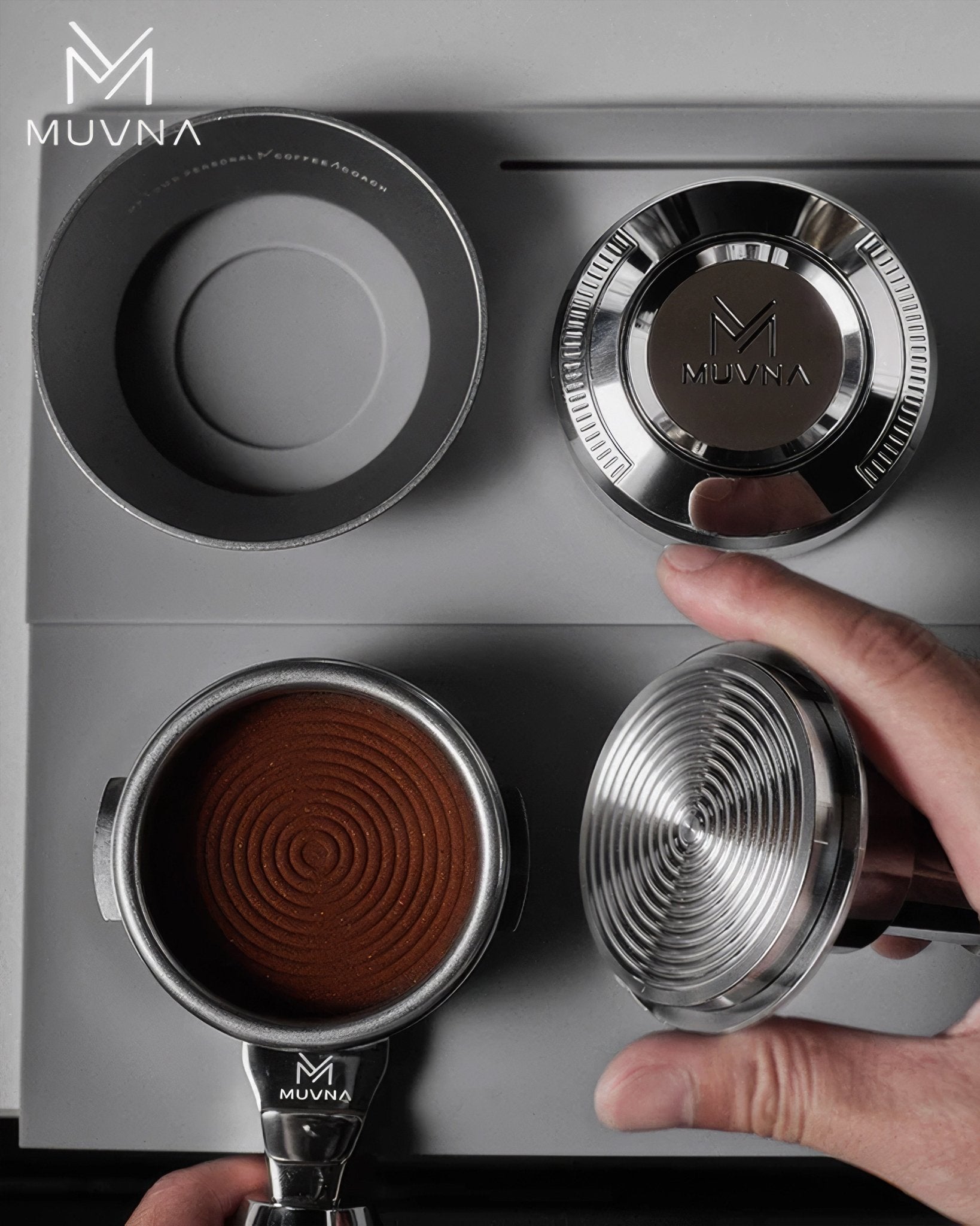 MUVNA coffee tamper and portafilter shown on espresso machine, with hand reaching for tamper, demonstrating consistent pressure for even coffee extraction