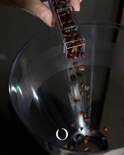 MUVNA coffee bean storage tube pouring roasted beans into a transparent container, showcasing precise measurement and freshness preservation for brewing