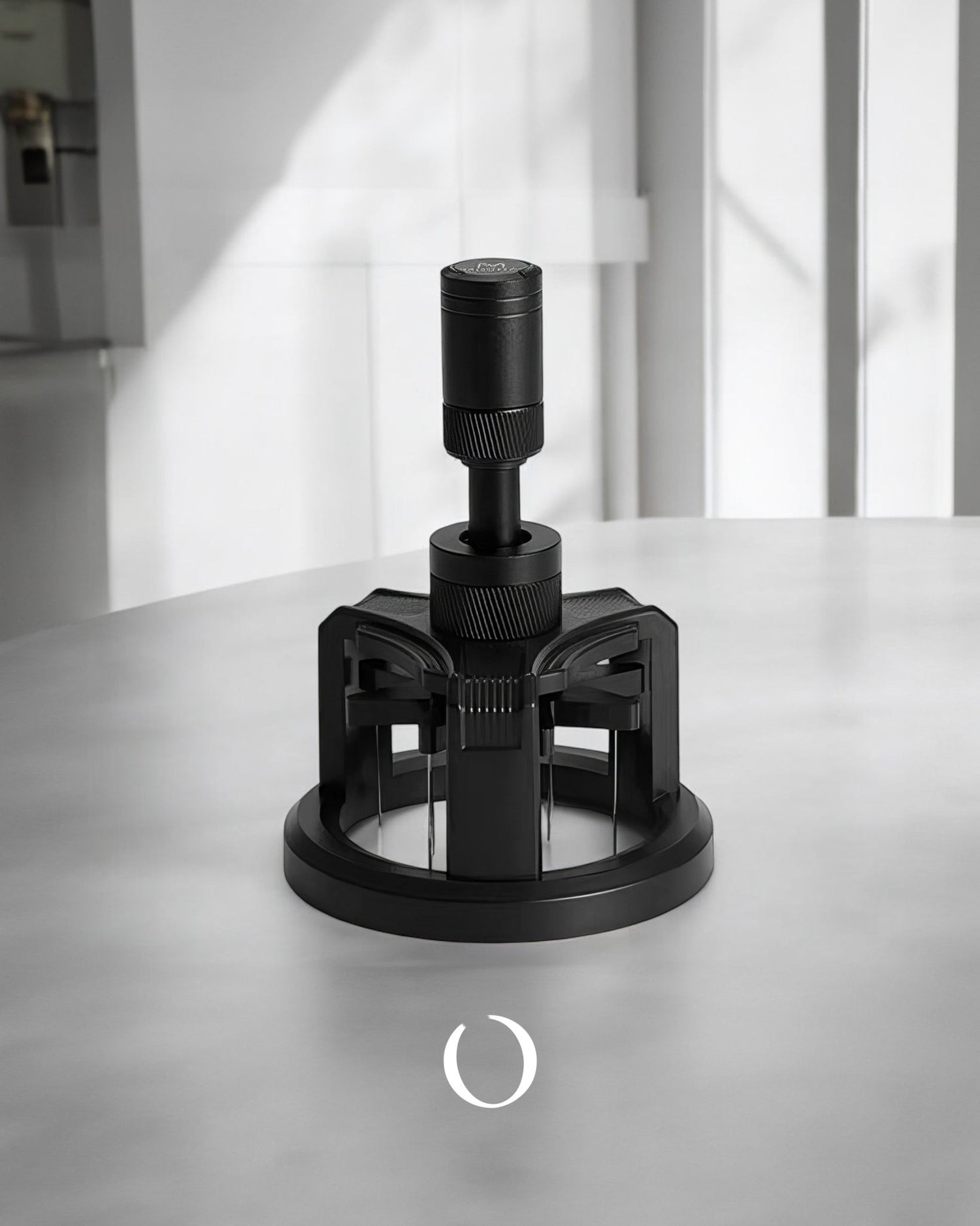 MUVNA Espresso WDT adjustable coffee distribution tool in black, featuring a circular base with multiple prongs and an adjustable top component, placed on a white surface in a minimalist setting