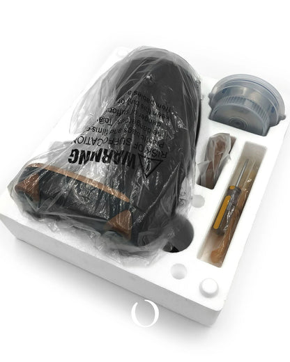 Niche Duo coffee grinder unboxing, showing the main unit in protective plastic wrap, with accessories like burrs and brushes neatly arranged in a white molded packaging tray