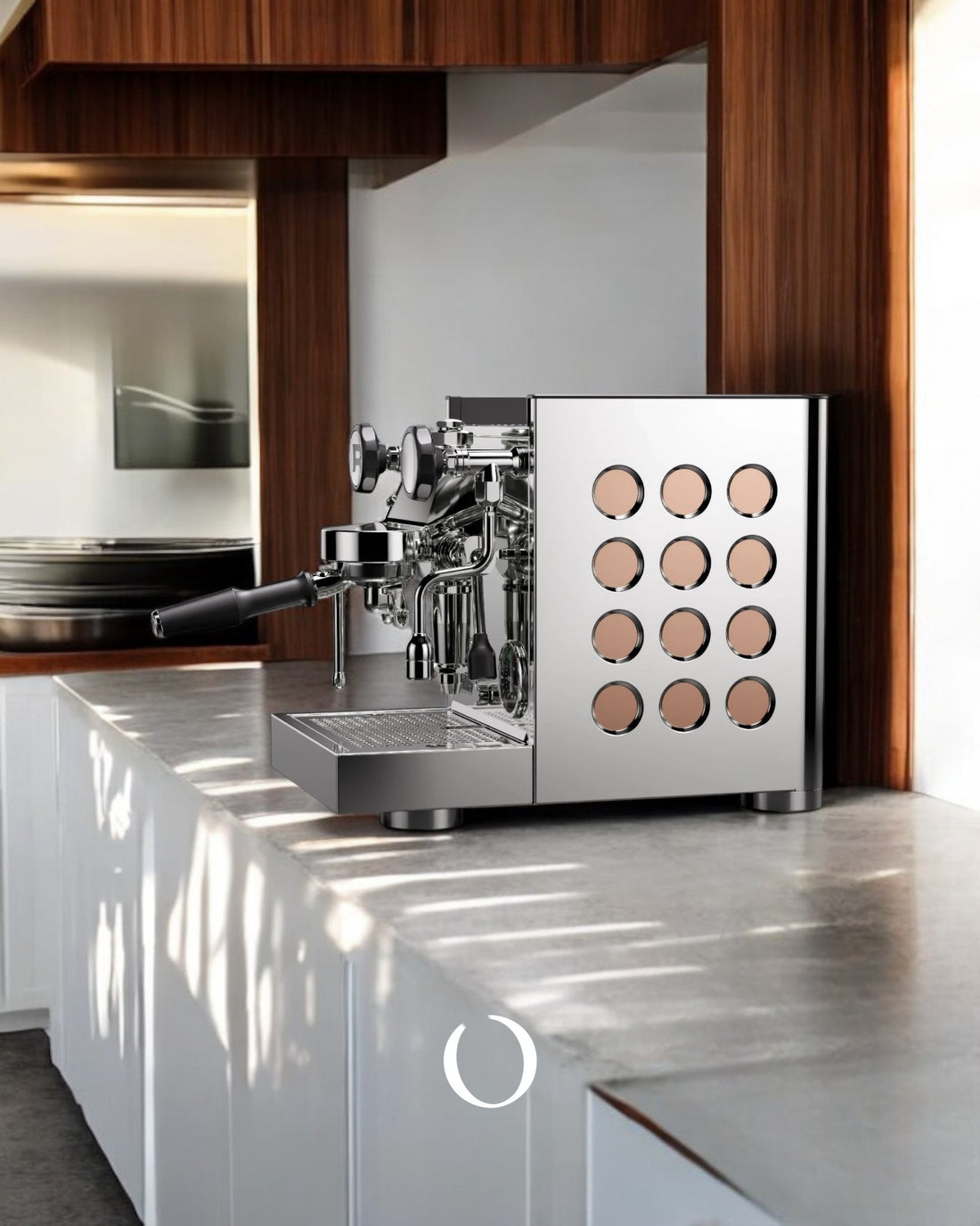 Sleek Rocket Appartamento TCA espresso machine on modern kitchen counter, featuring stainless steel body with unique circular pattern design, positioned against warm wood cabinetry in sunlit space.