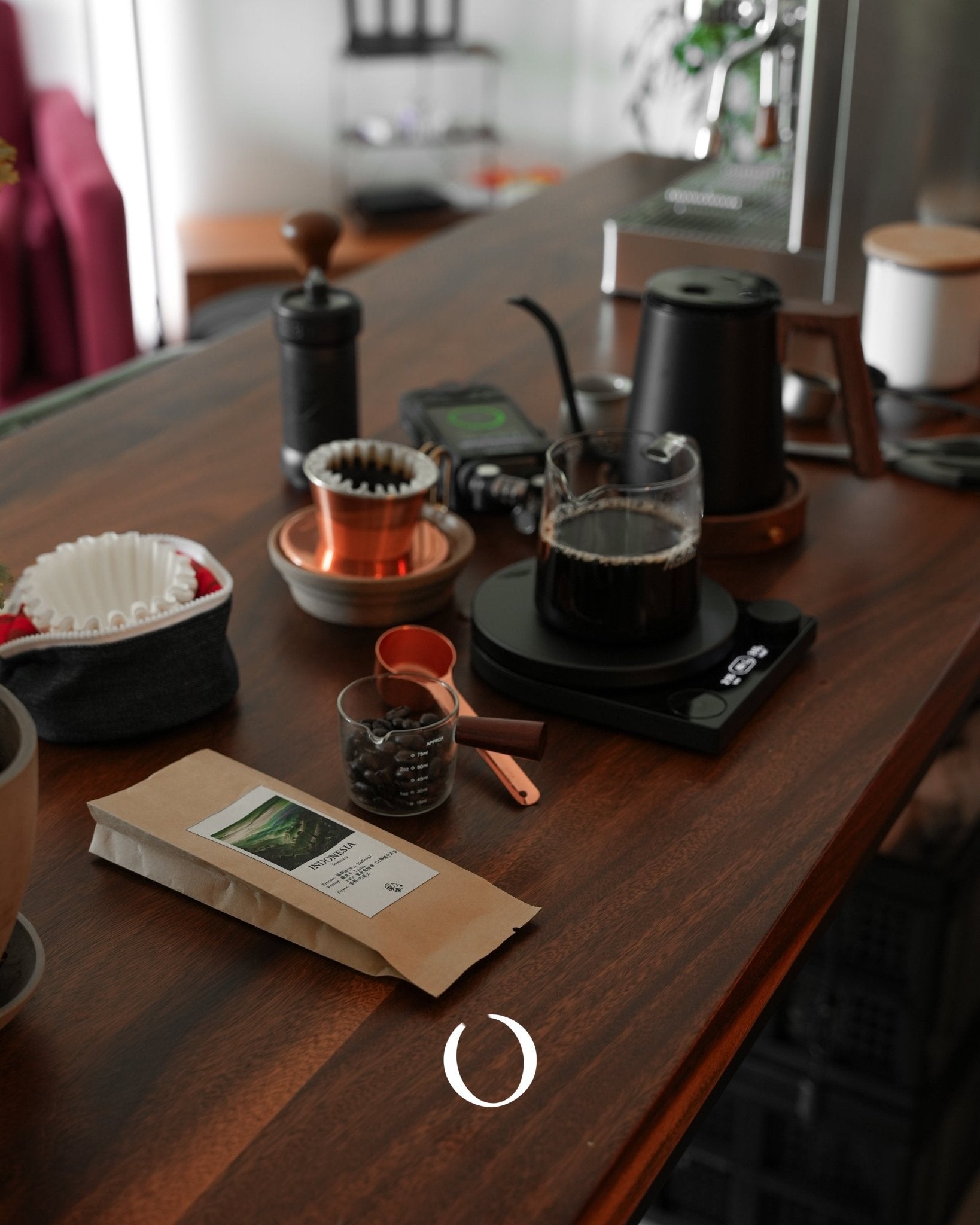 Coffee brewing setup on wooden table with grinder, filters, scale, coffee beans, and Santos Brazil coffee package from Sip Coffee, showcasing various brewing methods and equipment