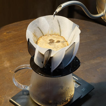 HARIO V60 SUIREN 黑白款架在玻璃壺上，熱水正注入濾紙中的咖啡粉