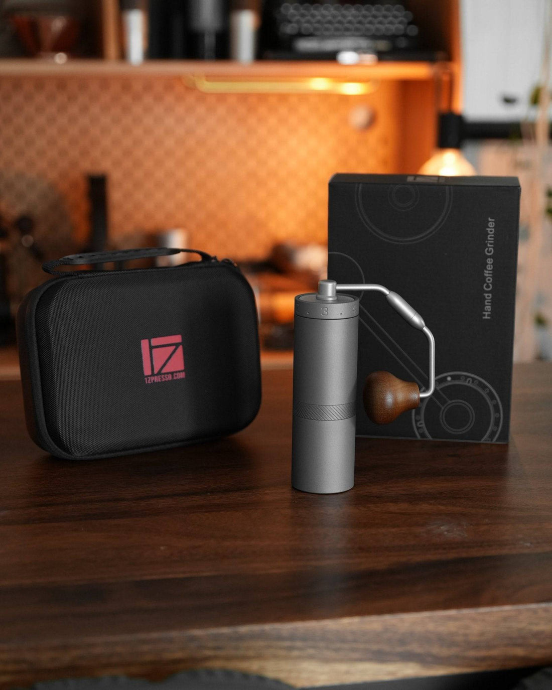 1Zpresso X-Ultra manual coffee grinder with carrying case and packaging on wooden table in kitchen setting, showcasing portable design and premium quality for coffee enthusiasts