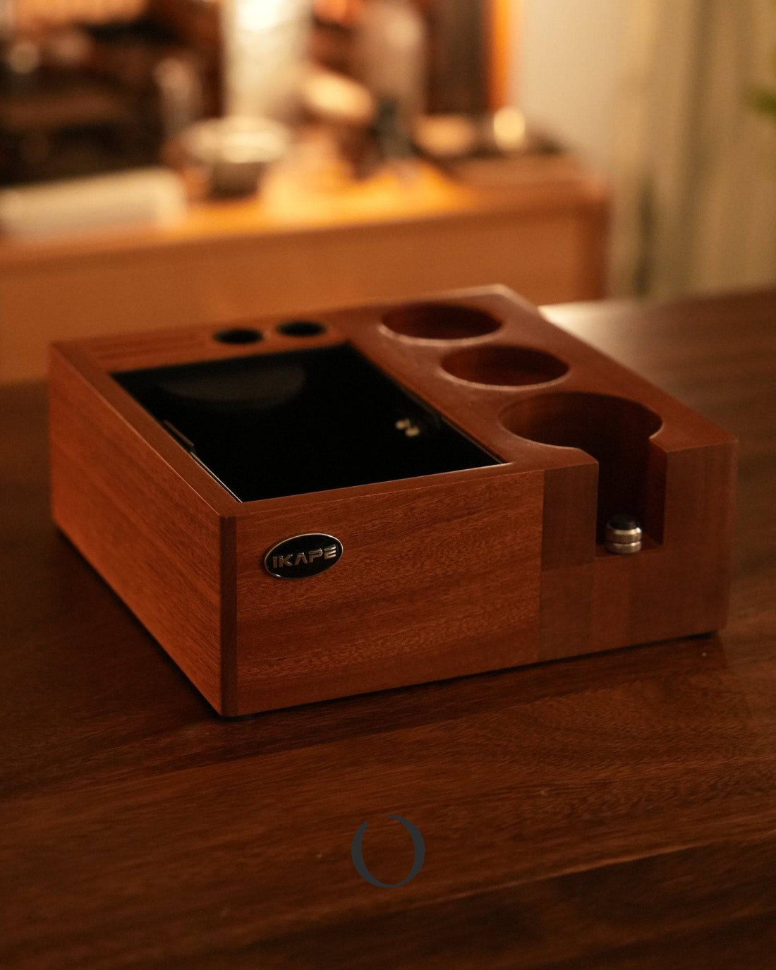 Ikape V2 Espresso Knock box on wooden table, featuring a sleek walnut design with multiple compartments for coffee tools, including a central knock box area and circular holders for tampers and accessories, showcasing its 8-in-1 functionality for efficient espresso workflow