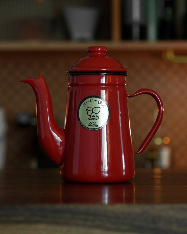 Kalita red enamel pour-over kettle with gooseneck spout, 1L capacity, featuring Kalita logo on side, displayed on wooden counter in kitchen setting