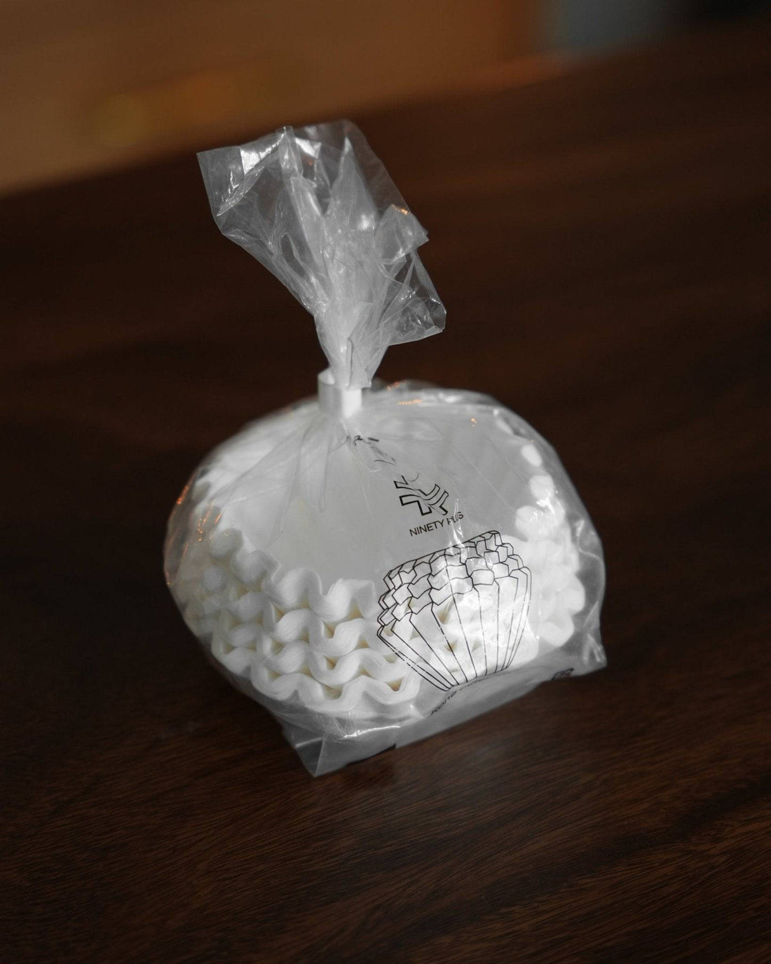 Ninety Plus Coffee Kone Filter 10.1 flat-bottom paper filters in a transparent plastic package, showcasing the product&