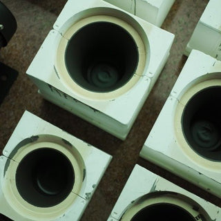 Dark, still-liquid slip inside several white plaster moulds, viewed from above