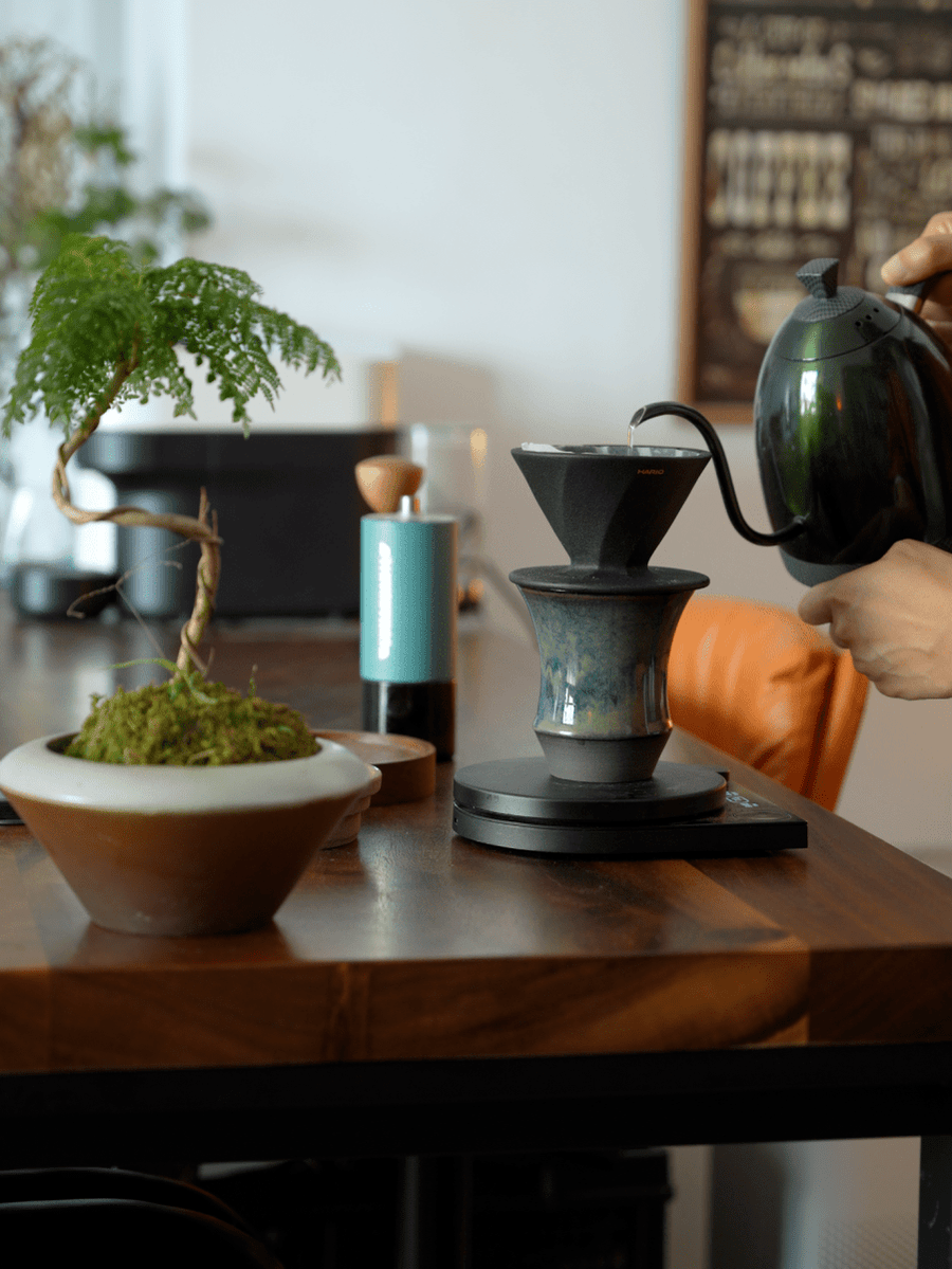 黑色濾杯直接架在 Coffee Stage Sharing Cup L Size 杯口上，手沖壺正在注水，杯子放在電子磅上