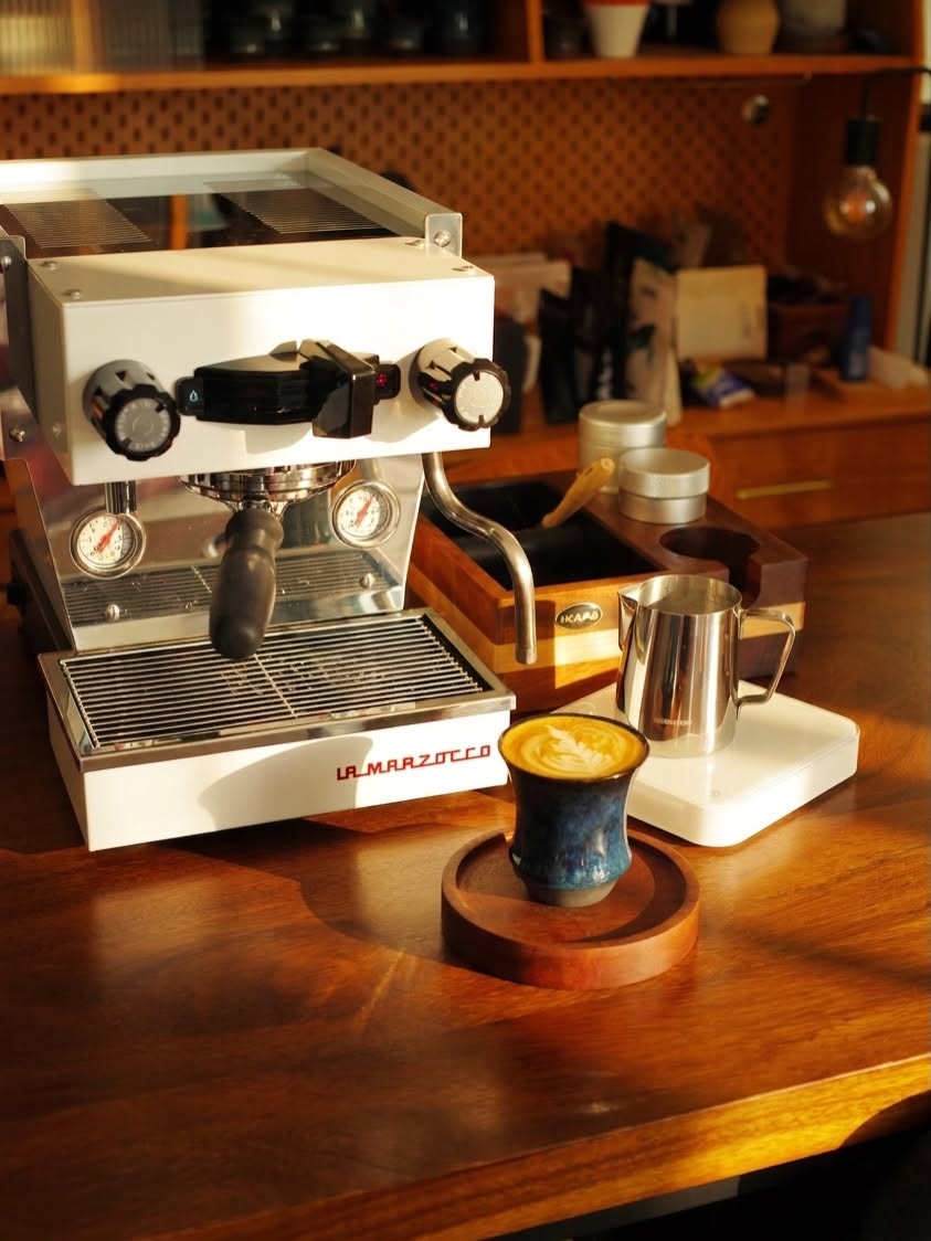 Coffee Stage Sharing Cup M Size 盛載奶啡，放在意式咖啡機前的木桌上